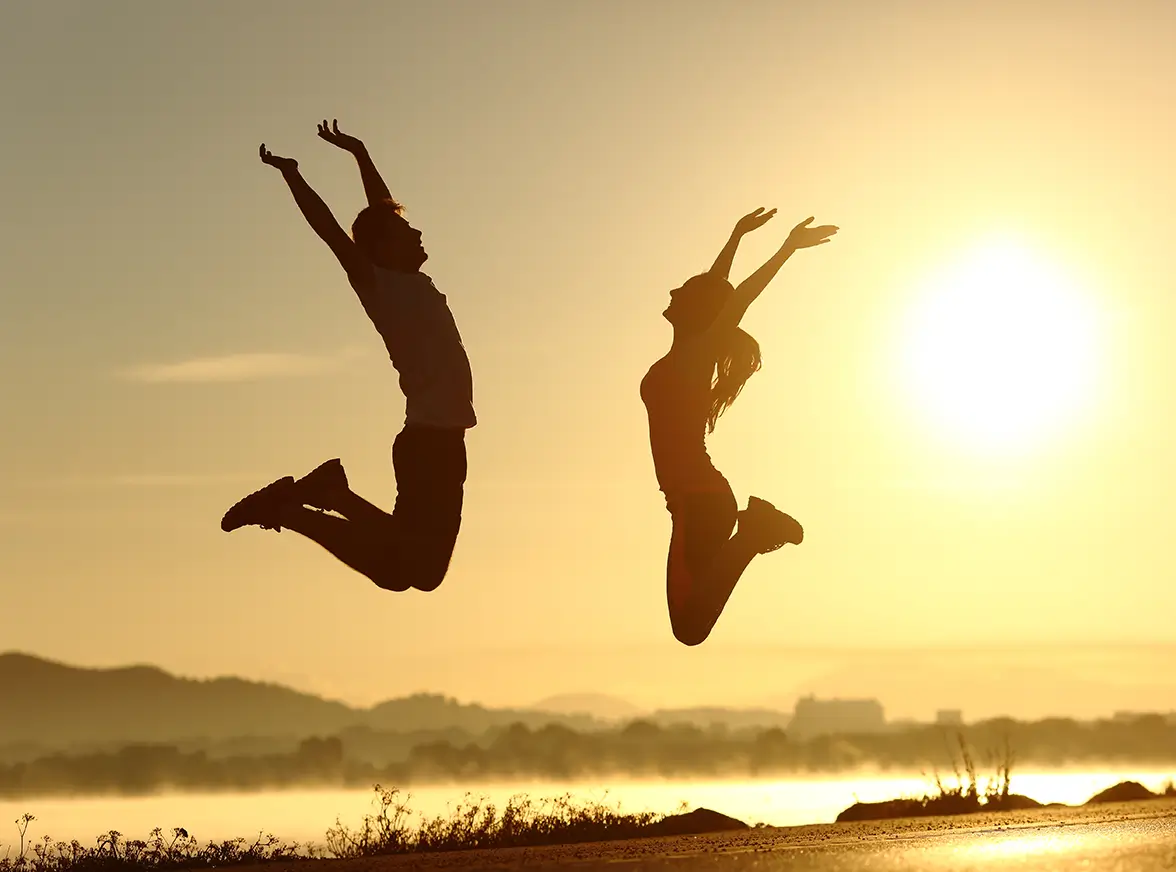 A person jumping joyfully in an outdoor South African setting, symbolizing the energy and freedom gained through successful medical weight management.